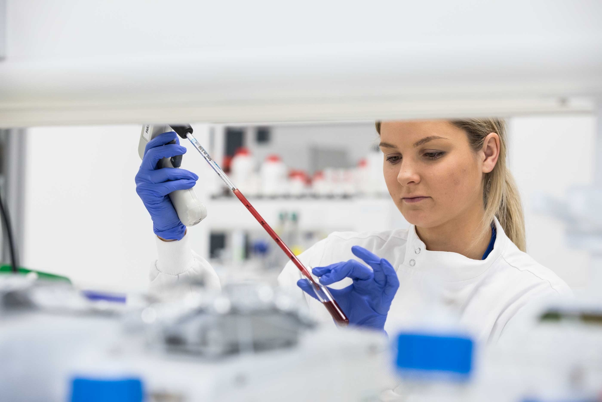 A woman wearing a laboratory safety gear works in a lab