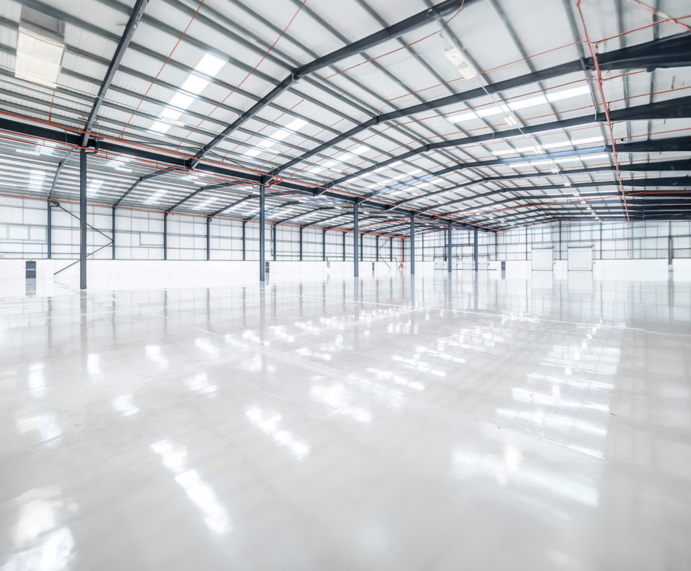 An image of the inside of a large, modern, empty warehouse