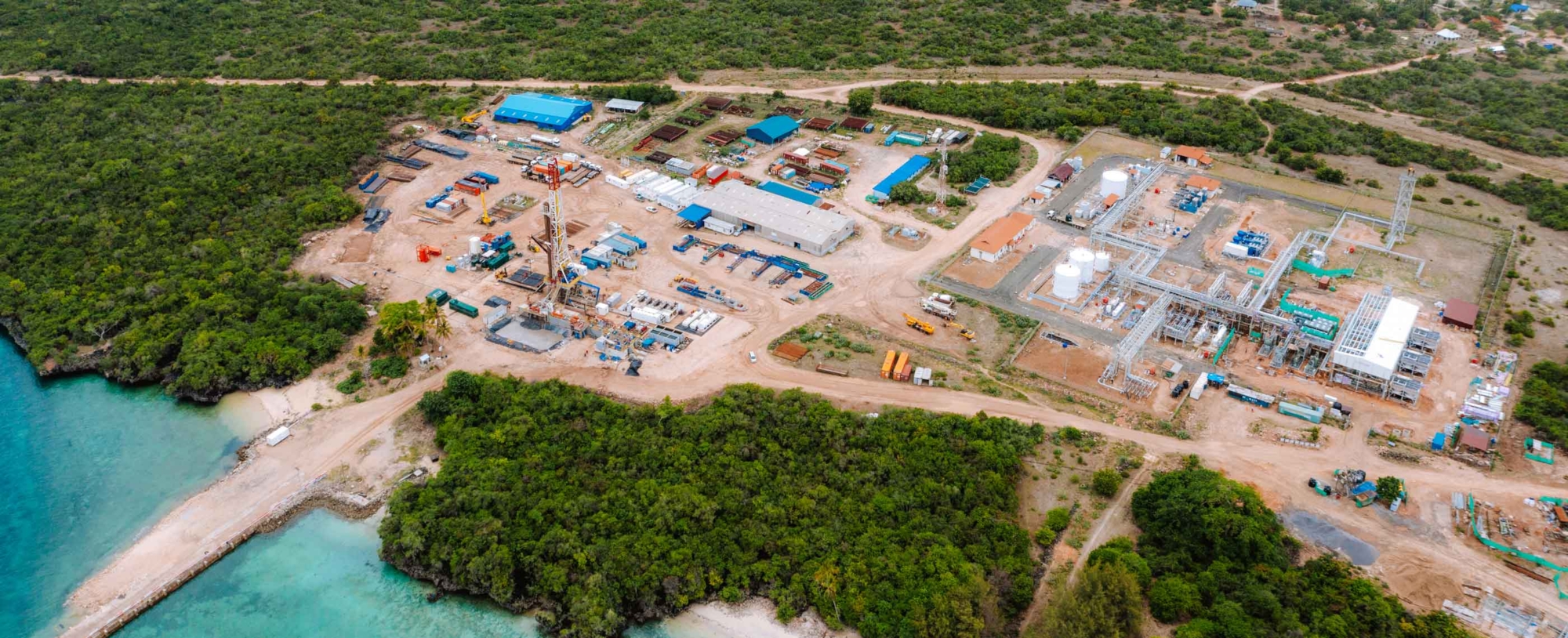 A working coastal gas plant surrounded by dense greenery