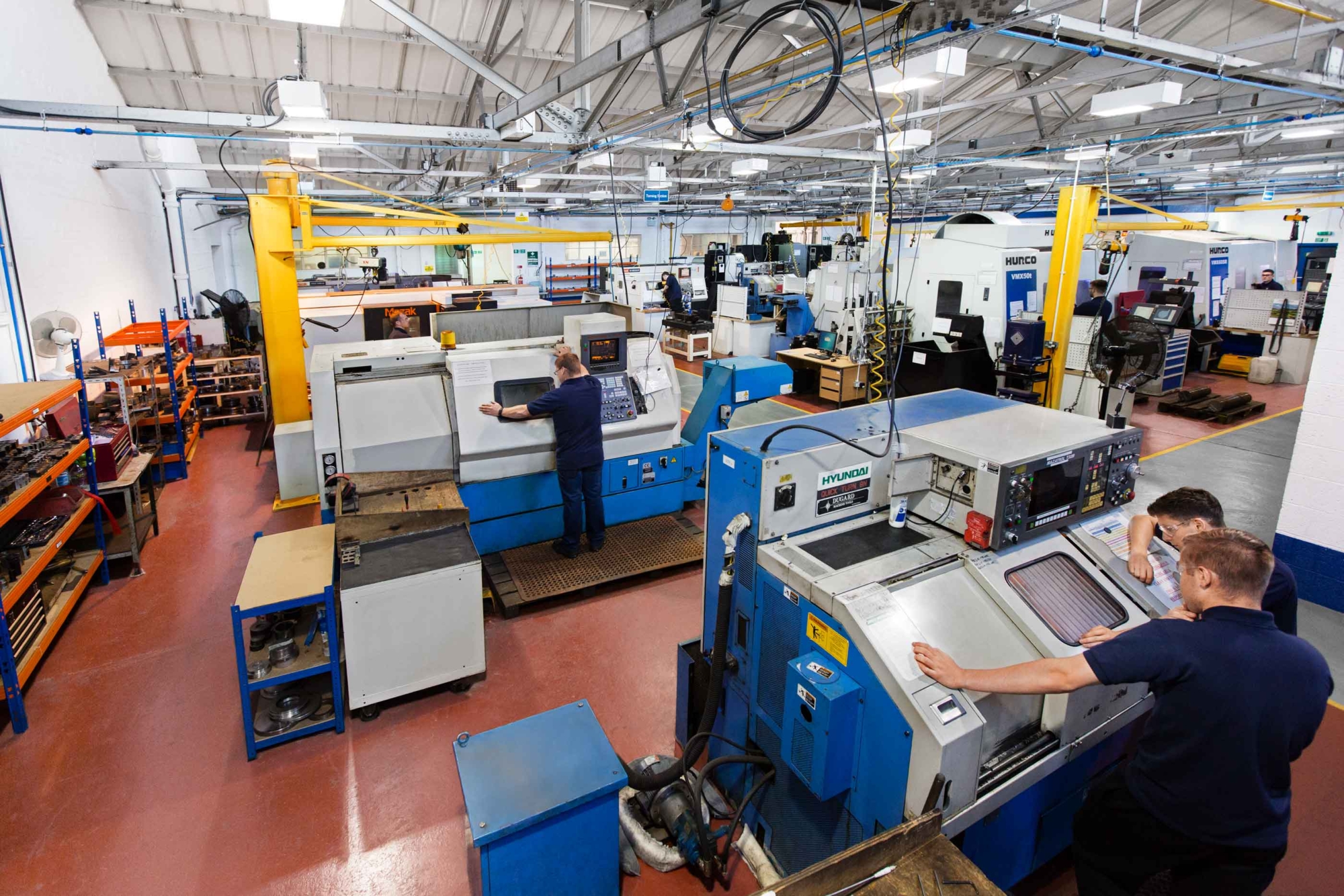 A wide view of a factory floor showing Pressure Technologies employees at work